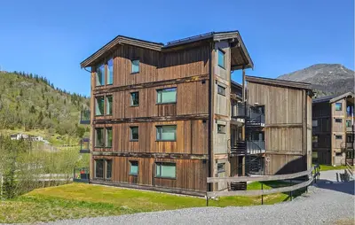 a tall wooden building with a mountain in the background at 3 Bedroom Awesome Apartment In Hemsedal in Hemsedal