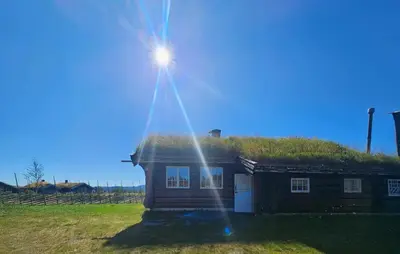 a house with a grass roof with the sun shining on it at Lovely Home In Røn With House A Mountain View in Ron
