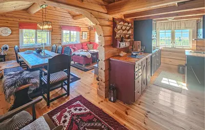 a living room with a table in a log cabin at Lovely Home In Røn With House A Mountain View in Ron