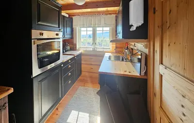 a kitchen with black cabinets and a sink at Lovely Home In Røn With House A Mountain View in Ron