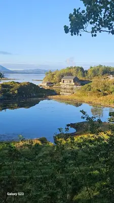 a house on the shore of a body of water at Sjåen på Balsnes Gård in Hitra
