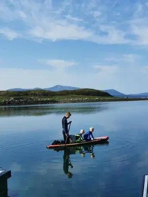 two people on a paddle board in the water at Sjåen på Balsnes Gård in Hitra