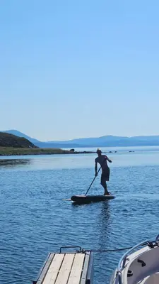 a person on a paddle board on the water at Sjåen på Balsnes Gård in Hitra
