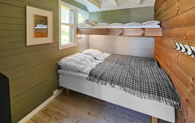 a bedroom with a bed in a wooden wall at 5 Bedroom Stunning Home In Eggedal in Eggedal