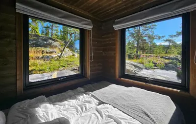 a bed in a small room with two windows at 5 Bedroom Stunning Home In Eggedal in Eggedal