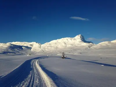 a snow covered mountain with a road in front of it at Central on Beitostølen with walking distance to everything in Beitostøl