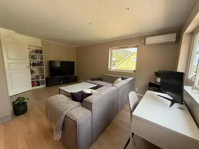 a living room with a couch and a tv at Moderne 3-roms nær sentrum in Bergen