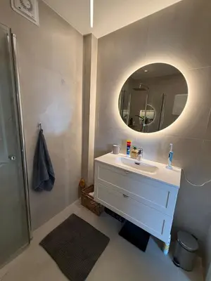 a bathroom with a white sink and a mirror at Moderne 3-roms nær sentrum in Bergen