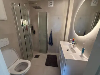 a bathroom with a shower and a toilet and a sink at Moderne 3-roms nær sentrum in Bergen