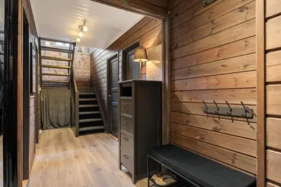 a tiny house with a staircase and a wooden wall at Fagertoppen 1314B by Vacation Trysil in Trysil