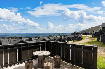 a balcony with a table and a view of a town at Fagertoppen 1314B by Vacation Trysil in Trysil