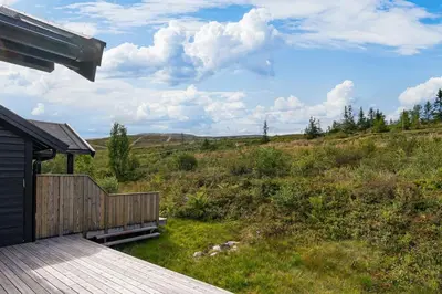 a wooden deck with a view of a field at Fagertoppen 1314B by Vacation Trysil in Trysil