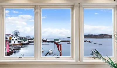 a window with three views of a marina at Fjordside Escape - Spacious apartment with amazing views in Tysnes