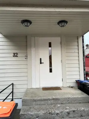 a white front door of a house with aphalt at Fjordside Escape - Spacious apartment with amazing views in Tysnes