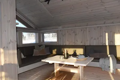 a living room with a couch and a table at Hedda Lenningen - 3 bedroom cabin with view towards Langsua National Park in Etnedal
