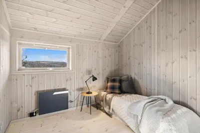 a bedroom with a bed and a television in it at Hedda Lenningen - 3 bedroom cabin with view towards Langsua National Park in Etnedal