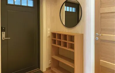 a hallway with a black door and a mirror at Cozy Apartment In Gurskøy With Sauna in Kjellsund