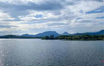 a large body of water with mountains in the background at Cozy Apartment In Gurskøy With Sauna in Kjellsund