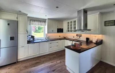 a large kitchen with white cabinets and a sink at Amazing Home In Rubbestadneset With Wifi in Rubbestadneset