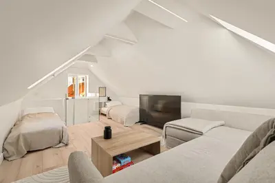 a white living room with a couch and a tv at Historisk hus fra 1800-tallet in Bergen