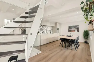 a kitchen and dining room with a staircase in a house at Historisk hus fra 1800-tallet in Bergen