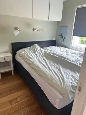 a large bed in a bedroom with a window at Flott bolig på Øvre kleppe med fine solforhold og fin uteplass in Askøy
