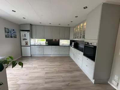 a kitchen with white cabinets and black appliances at Flott bolig på Øvre kleppe med fine solforhold og fin uteplass in Askøy