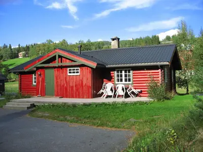 a red shed with two horses standing outside of it at Tveitehaug cabin, 3-4 bedroom cabin close to ski center in Ål