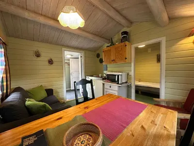 a living room with a table and a kitchen at Bjorliheimen Fjellhotell-Hytte 6 in Bjorli