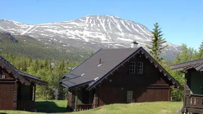 a house with a mountain in the background at Kvitåvatn Fjellhytter in Gaustablikk