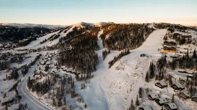 an aerial view of a snow covered mountain with trees at Kvitåvatn Fjellhytter in Gaustablikk
