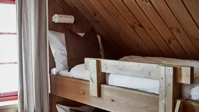 a room with a bed in a wooden cabin at Kvitåvatn Fjellhytter in Gaustablikk