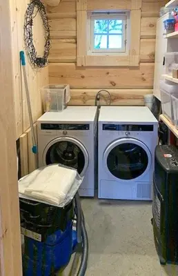 a laundry room with two washing machines and a window at Log Cabin With Panoramic Views Of Hallingskarvet in Holo