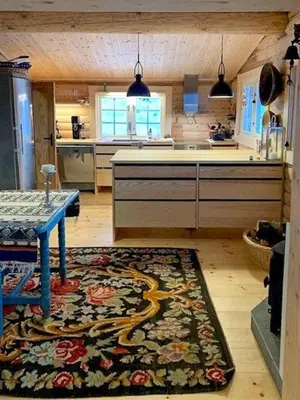 a kitchen with a table and a rug on the floor at Log Cabin With Panoramic Views Of Hallingskarvet in Holo