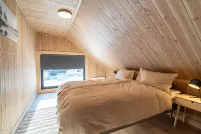 a bedroom with a bed in a wooden room at Cabin at Norefjell ski resort, nice view in Noresund