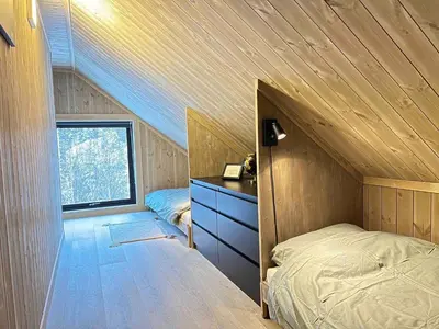 a bedroom with a bed and a dresser and a window at Cabin at Norefjell ski resort, nice view in Noresund