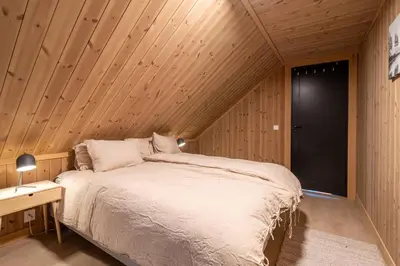 a bedroom with a bed in a wooden room at Cabin at Norefjell ski resort, nice view in Noresund