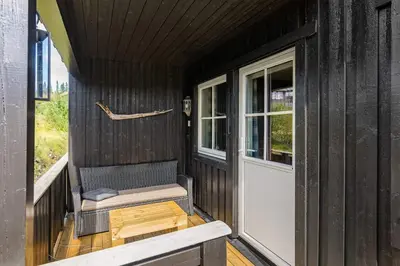 a screened in porch with a bench and a door at Fagerasen 790D by Vacation Trysil in Trysil