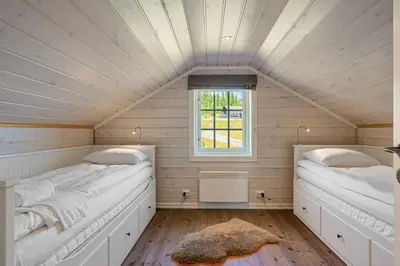 two beds in a room with a window at Solsiden 16B by Vacation Trysil in Trysil