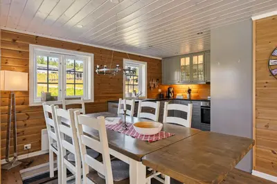 a kitchen with a wooden table and white chairs at Solsiden 16B by Vacation Trysil in Trysil