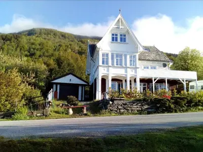 a large white house on the side of a road at Gemütliche Ferienwohnung am Fjord