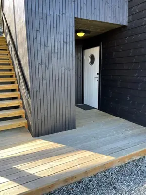 a wooden ramp leading to a white door with a white door at Ferieleilighet i Tråstølen in Vossevangen