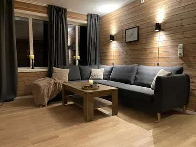 a living room with a blue couch and a table at Ferieleilighet i Tråstølen in Vossevangen