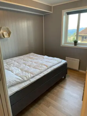 a bed in a room with a window at Ferieleilighet i Tråstølen in Vossevangen