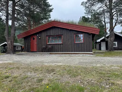 a small wooden building with a red door at Bjorliheimen Fjellhotell-Hytte 9 in Bjorli