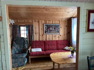 a living room with a red couch and a chair at Bjorliheimen Fjellhotell-Hytte 9 in Bjorli