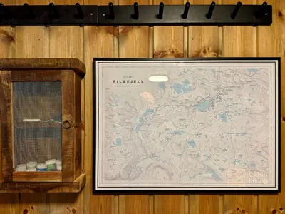 a framed map on a wooden wall next to a clock at Modern cabin sauna, BBQ & beautiful view Filefjell in Tyinkrysset