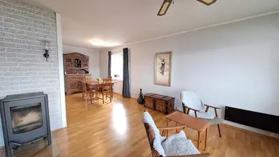 a living room with a fireplace and a table and chairs at Panorama by the fjord - Stryn in Stryn
