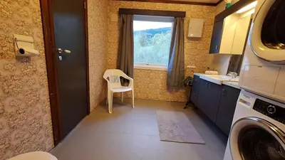 a small kitchen with a chair and a window at Panorama by the fjord - Stryn in Stryn