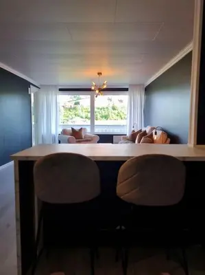 a living room with a table and chairs and a window at Nyoppusset leilighet nær Aker og sentrum in Stord